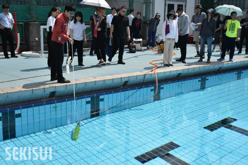 プールの⽔をポンプでマンホールトイレ(貯留型)まで引く
