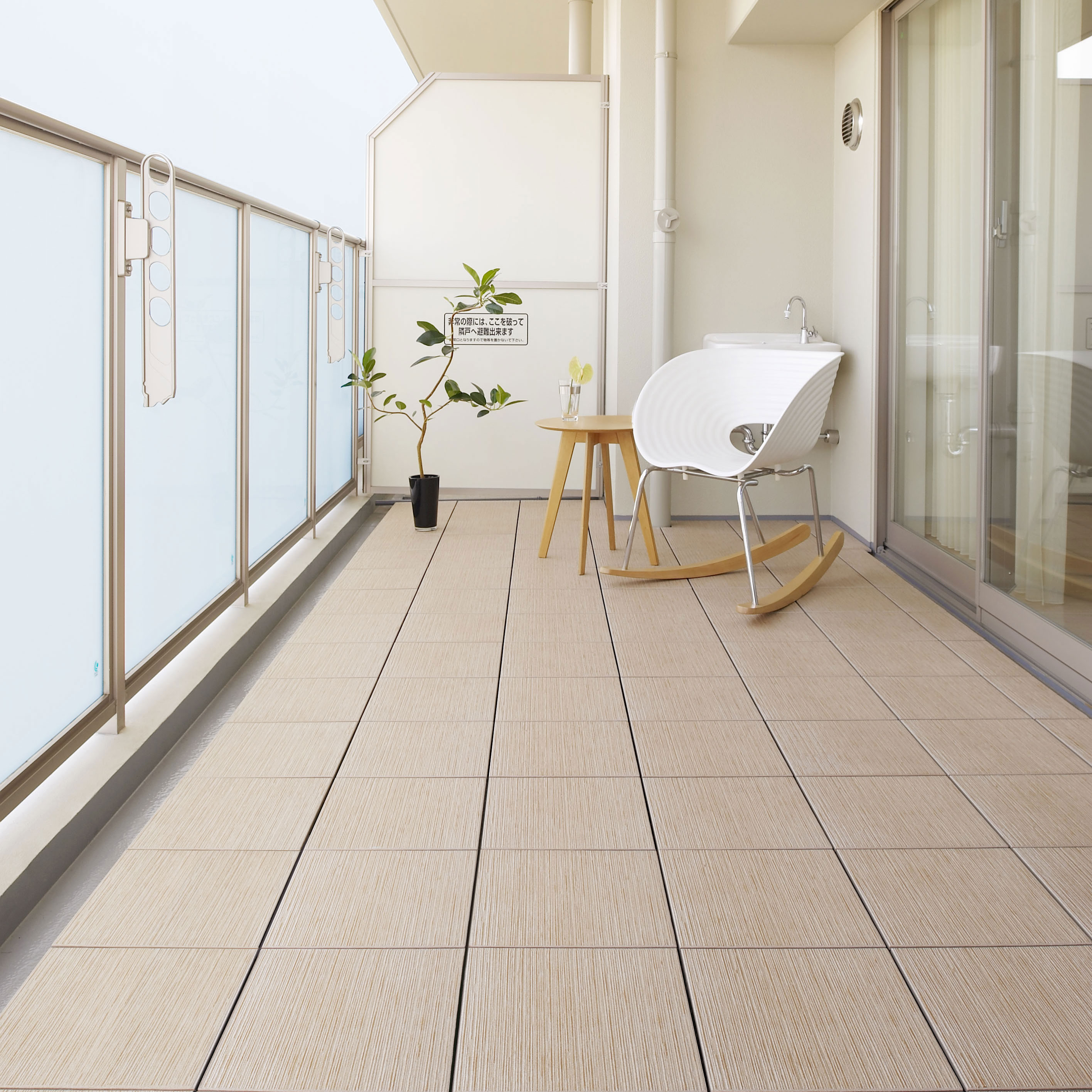 ナチュラルベージュのタイルが敷かれたベランダ・バルコニーにある白いロッキングチェア